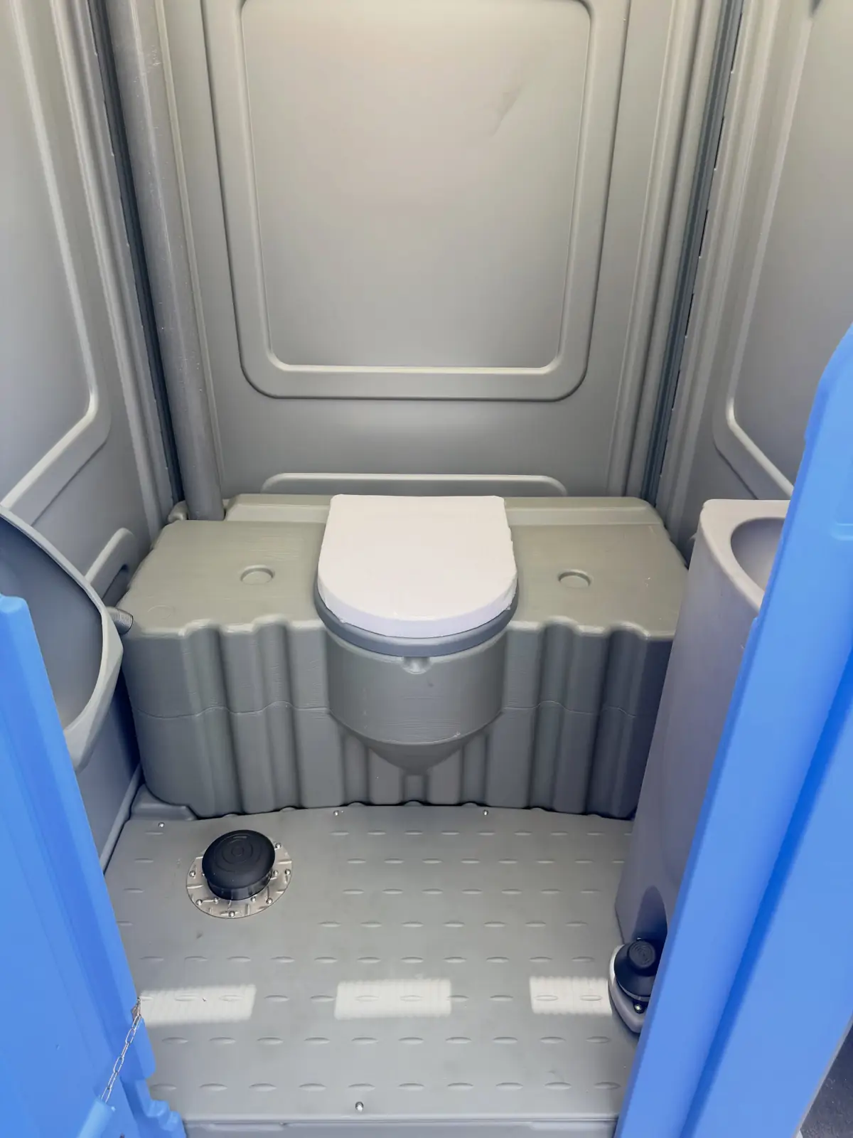 Wide interior of a large portable restroom with open floor space